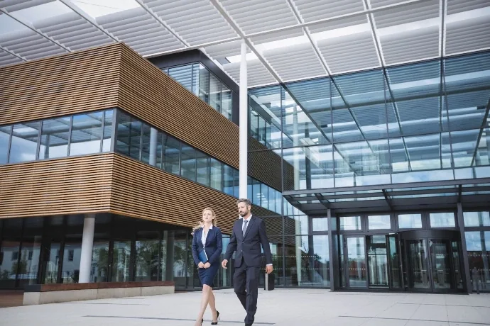 Business people walking outside an office, representing commercial impact