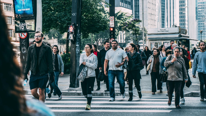 group of people walking across a pedestrian crossing
